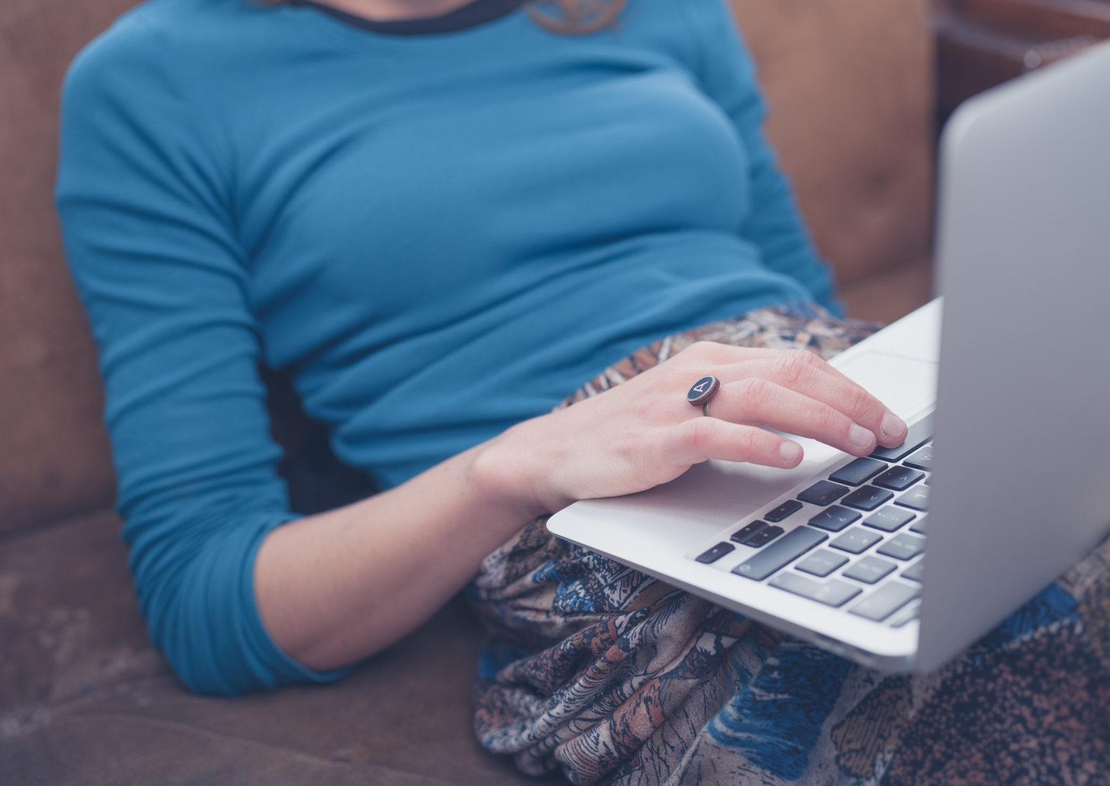 Person, bequem sitzend mit Laptop auf dem Schoß
